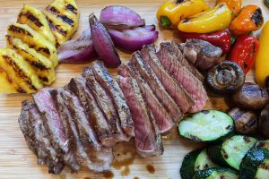 thinly sliced steak surrounded by grilled vegetables