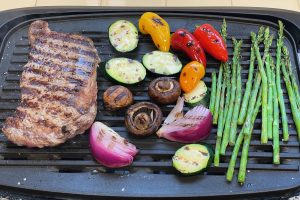 steak on grill with vegetables