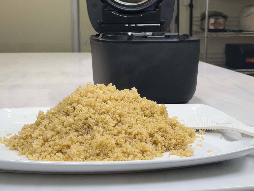  A plate of cooked quinoa with a rice cooker in the background.