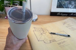 chocolate smoothie on desk next to architectural drawing