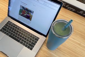 green smoothie on desk next to laptop