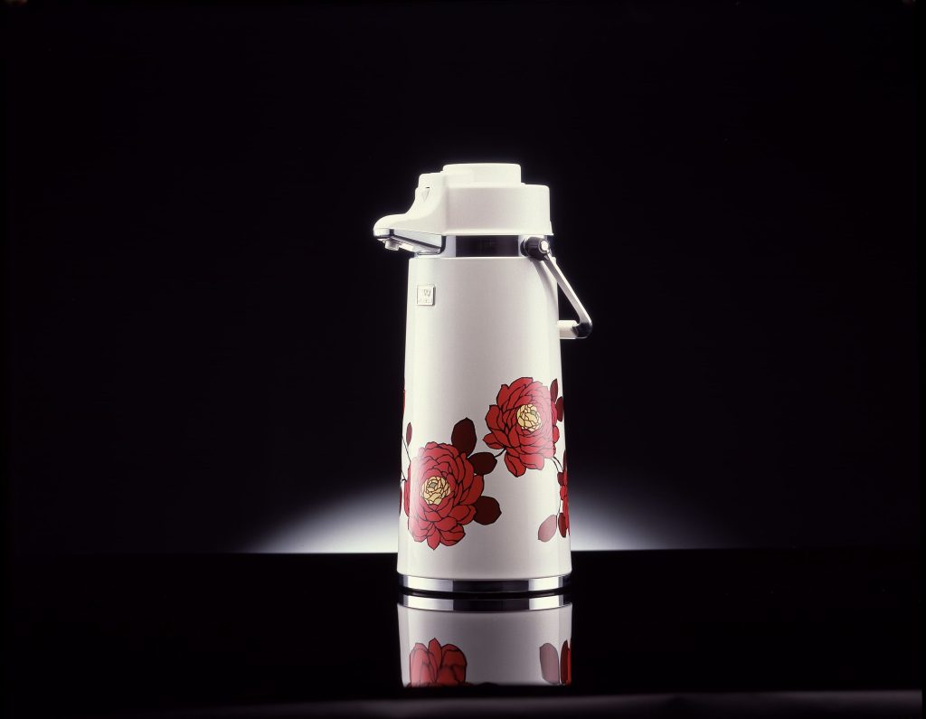 White air pot with Red flower pattern standing in a black background.