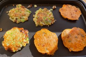 cooked okonomiyaki and pajeon on griddle