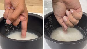 index finger in a rice cooker pan with rice and water