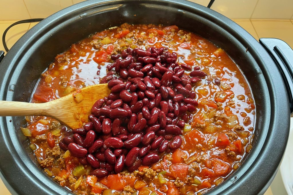 chili beans being added to sauce