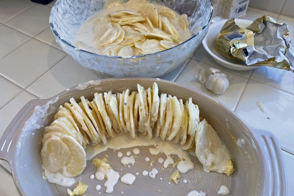 scalloped potatoes preparation in casserole dish