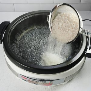 Putting uncooked rice in the electric skillet