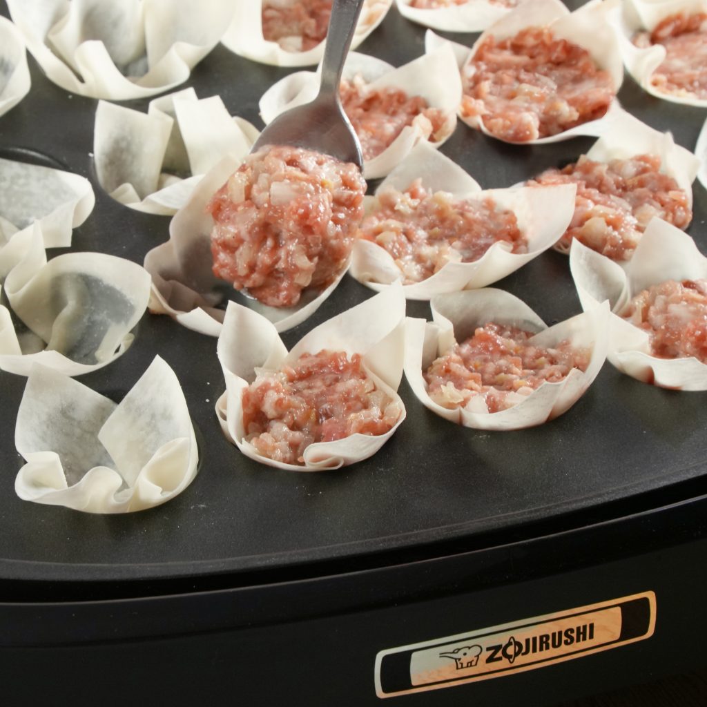 stuffing meat in the takoyaki plate